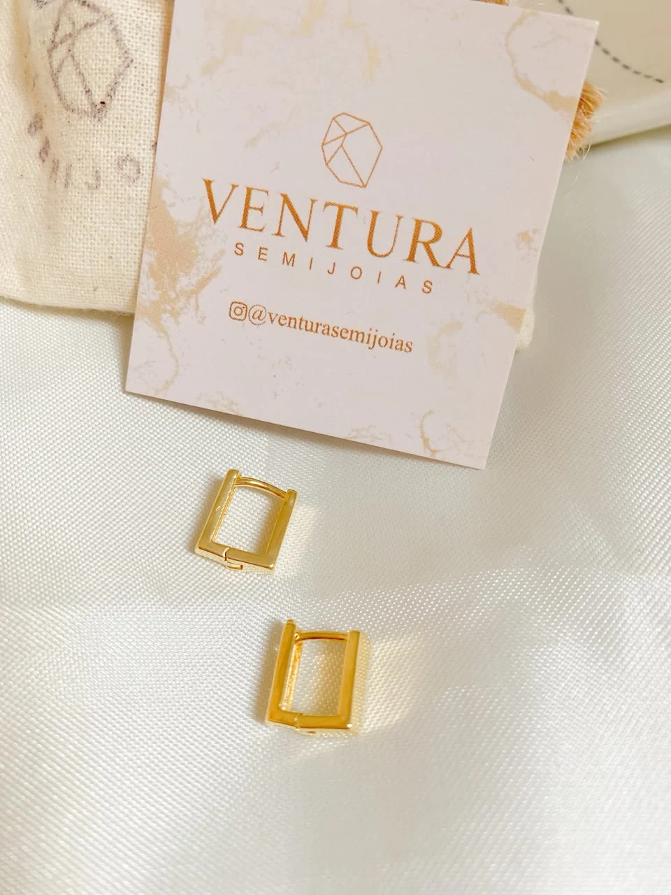 Brincos dourados com embalagem Ventura Semijoias